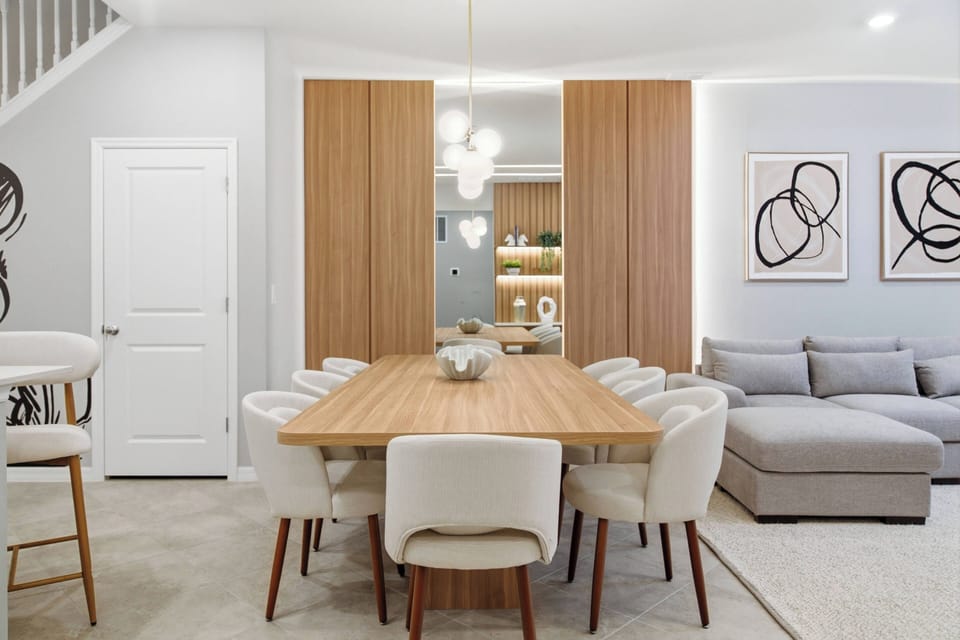 Gather around our spacious wooden dining table, surrounded by cozy white chairs, perfect for meals and meaningful conversations. Enjoy the natural light that highlights the modern decor, making for a warm and inviting atmosphere.