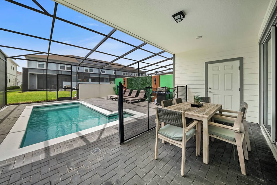 Experience your private oasis featuring a sleek pool and chic dining area nestled in lush greenery. Relax on comfy outdoor furniture and enjoy sunny days in the screened enclosure, ideal for unwinding and appreciating the scenery.