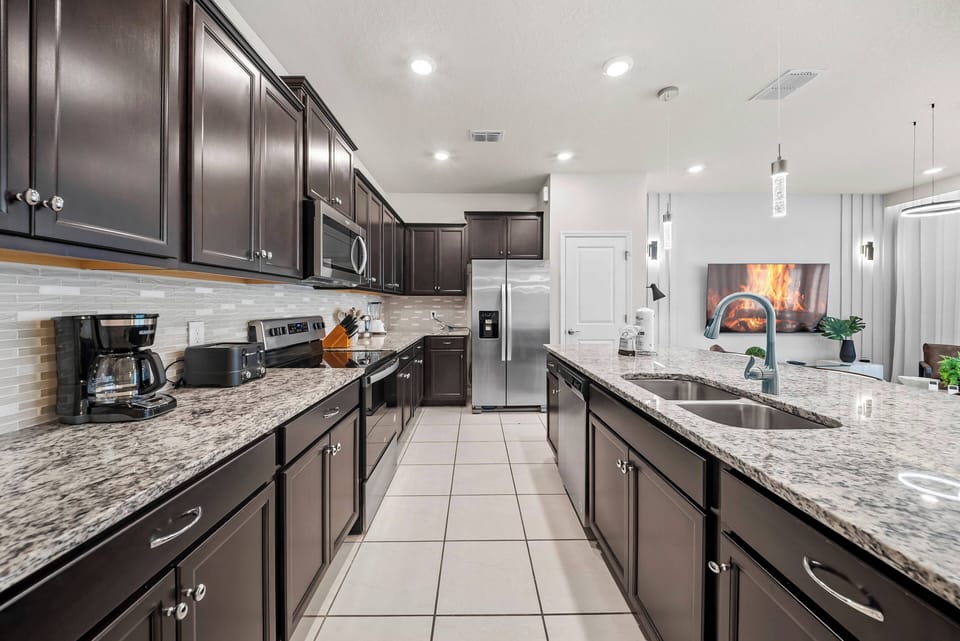 Enjoy a beautifully designed kitchen with rich wood cabinetry and stunning granite countertops that inspire your culinary creativity. The open layout and modern appliances create the perfect space for gathering and sharing meals.