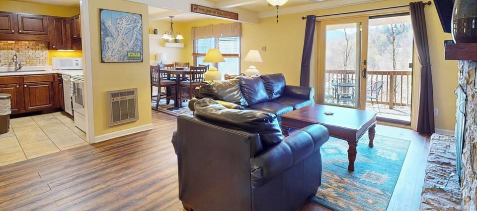 Sink into the plush leather sofa and enjoy your open-concept retreat with mountain views streaming through floor-to-ceiling windows.