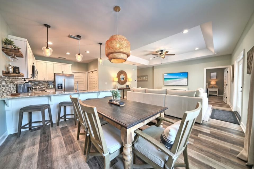 Open-concept living seamlessly connects the fully equipped kitchen, dining area, and comfortable living room, perfect for social gatherings at Beachside Dream. Enjoy family time with easy flow between spaces in this stylish coastal escape.