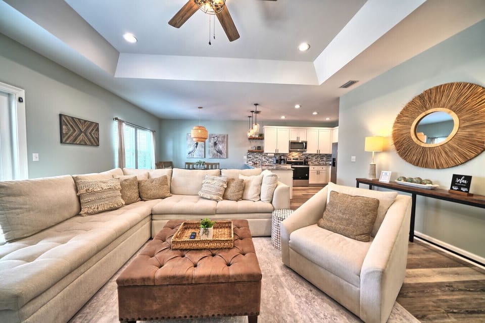 Welcome to your open-concept living space, designed for seamless entertaining and relaxation! Gather on the plush sectional sofa with chic decorative pillows, or enjoy a cozy armchair, all connecting to the full kitchen.