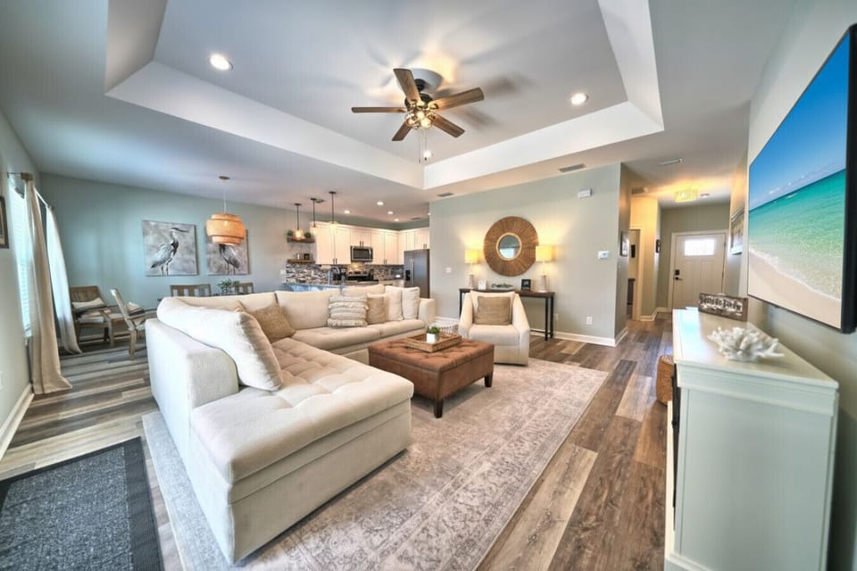 This stunning open-concept living area at Beachside Dream provides ample space for relaxation and entertaining, seamlessly connecting to the fully equipped kitchen and dining area.