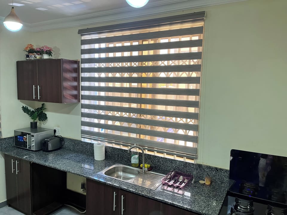 Full kitchen with microwave and toaster along with silverware and pots and pans