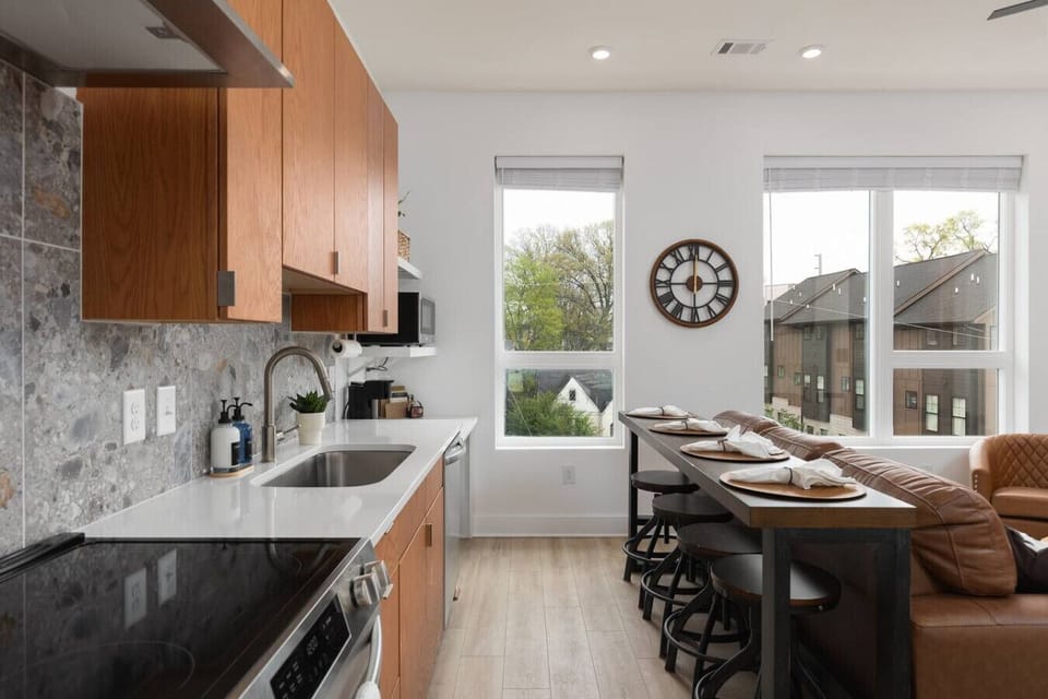 Open living area with a fully equipped kitchen and bar seating for four—perfect for meals, coffee, or cocktails.