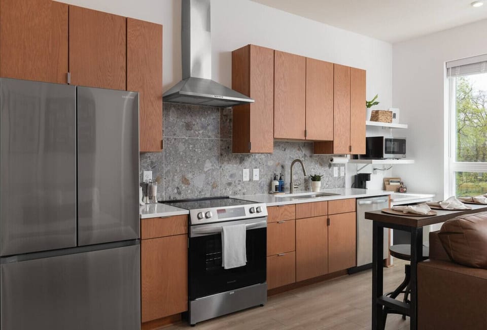 Open living area with a fully equipped kitchen and bar seating for four—perfect for meals, coffee, or cocktails.