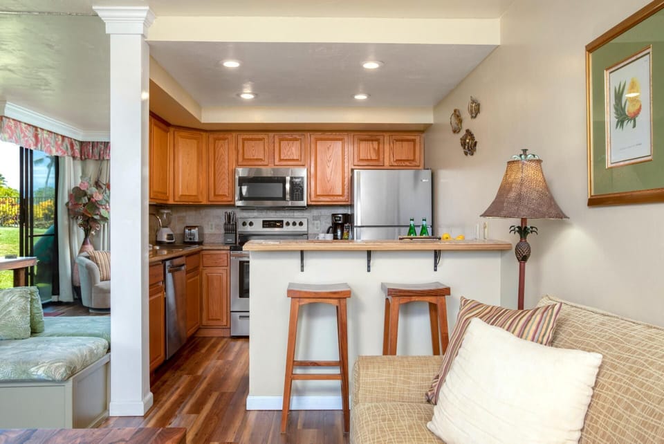 Cook with ease in this inviting kitchen with natural oak tones, bar seating, and thoughtful coastal decor touches   
