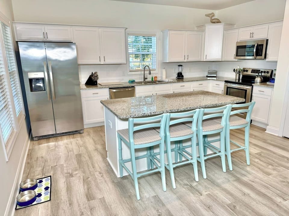 Enjoy cooking in this fully stocked kitchen with an island, bar seating, and a water view.