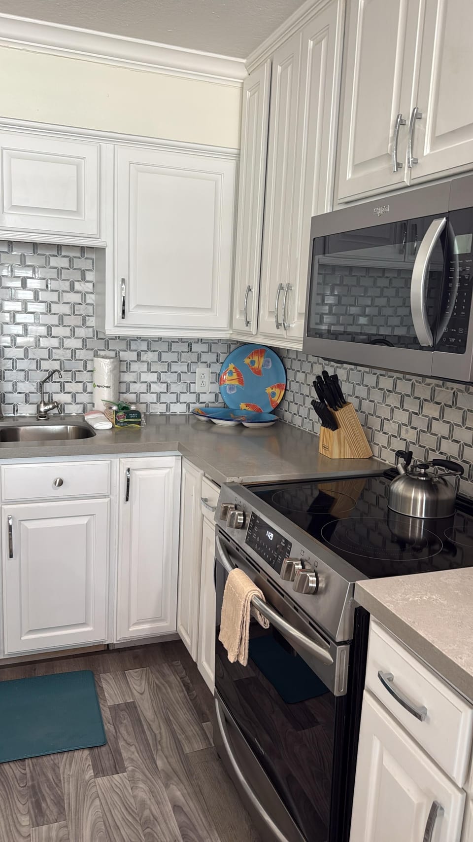 Bright modern kitchen with stainless appliances & stylish backsplash