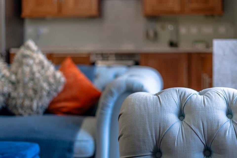- Closeup of sofa detail with textured pillows and soft fabric   - Bright colorful accents creating cozy modern living style   - Warm homely seating setup perfect for guests to unwind