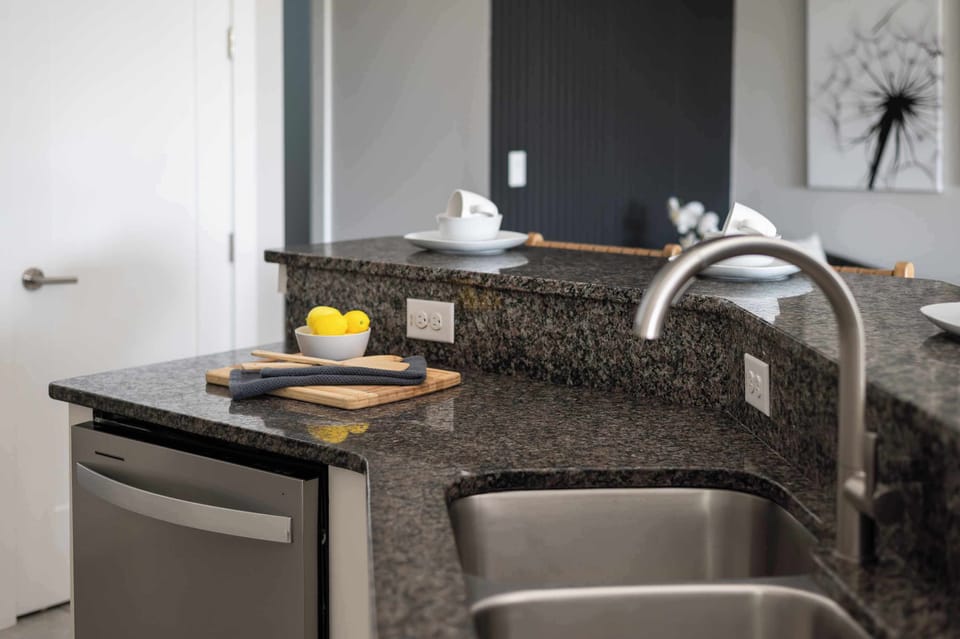 Sleek kitchen sink & prep area w/ granite counters for easy cooking and cleanup