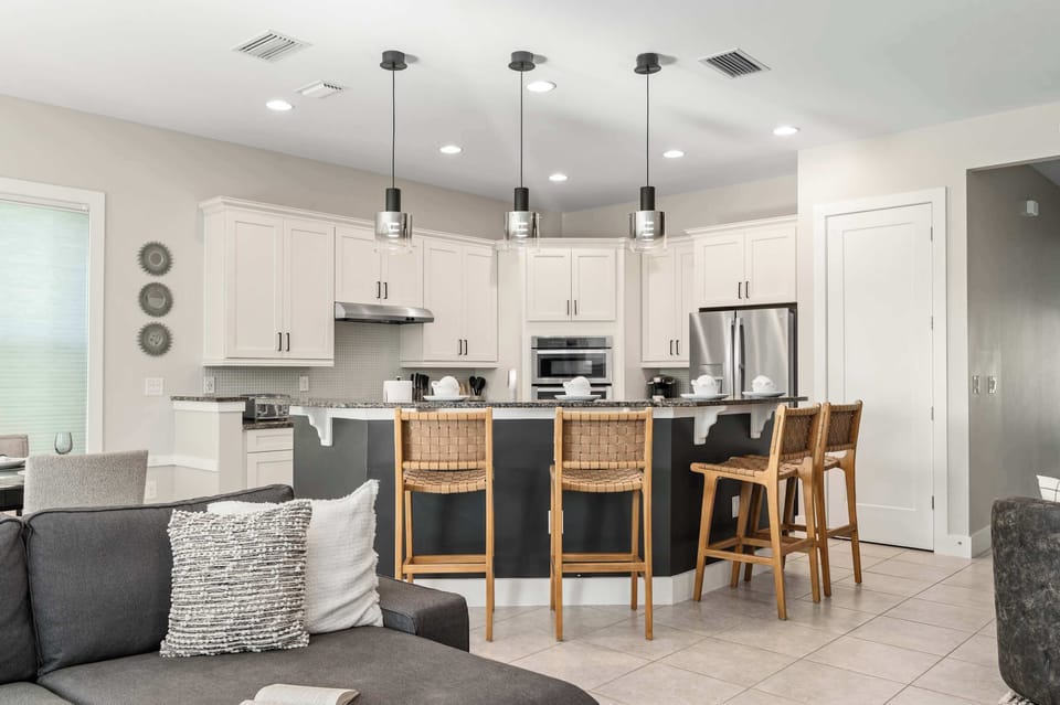 Open kitchen & living area w/ bar seating, modern finishes & bright natural light
