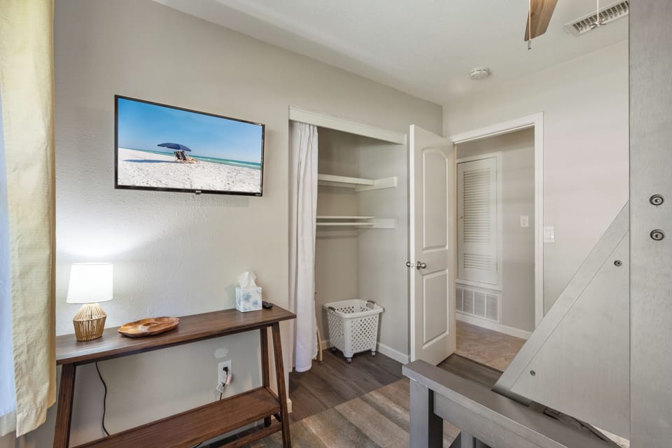 This thoughtfully organized bedroom offers a dedicated workspace, a wall-mounted smart TV for your favorite shows, and a spacious closet to keep your belongings tucked away.
