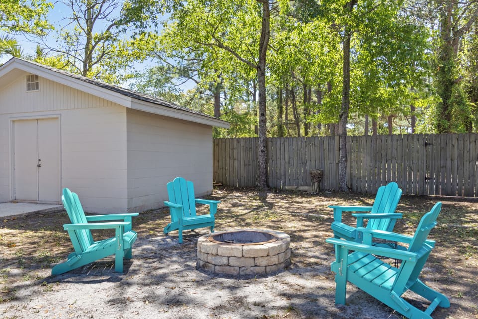 Gather around the stone fire pit in these vibrant Adirondack chairs, an ideal spot for roasting marshmallows under the afternoon sun.