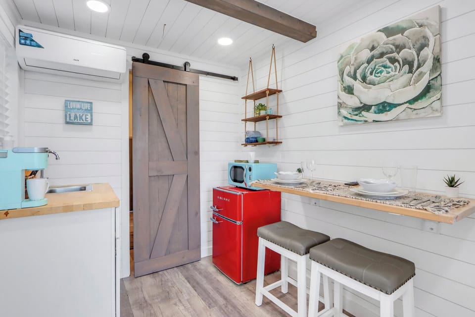 The kitchenette features rustic barn doors and overhead exposed beam