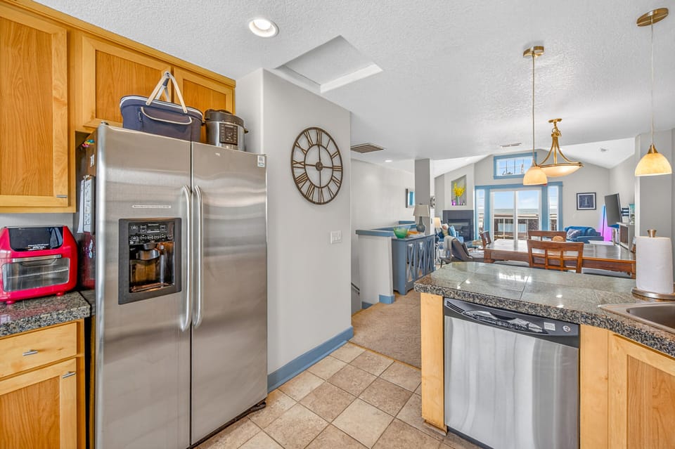 Your fully equipped kitchen features stainless steel appliances, granite countertops, and warm wood cabinetry, perfect for preparing memorable meals together.
