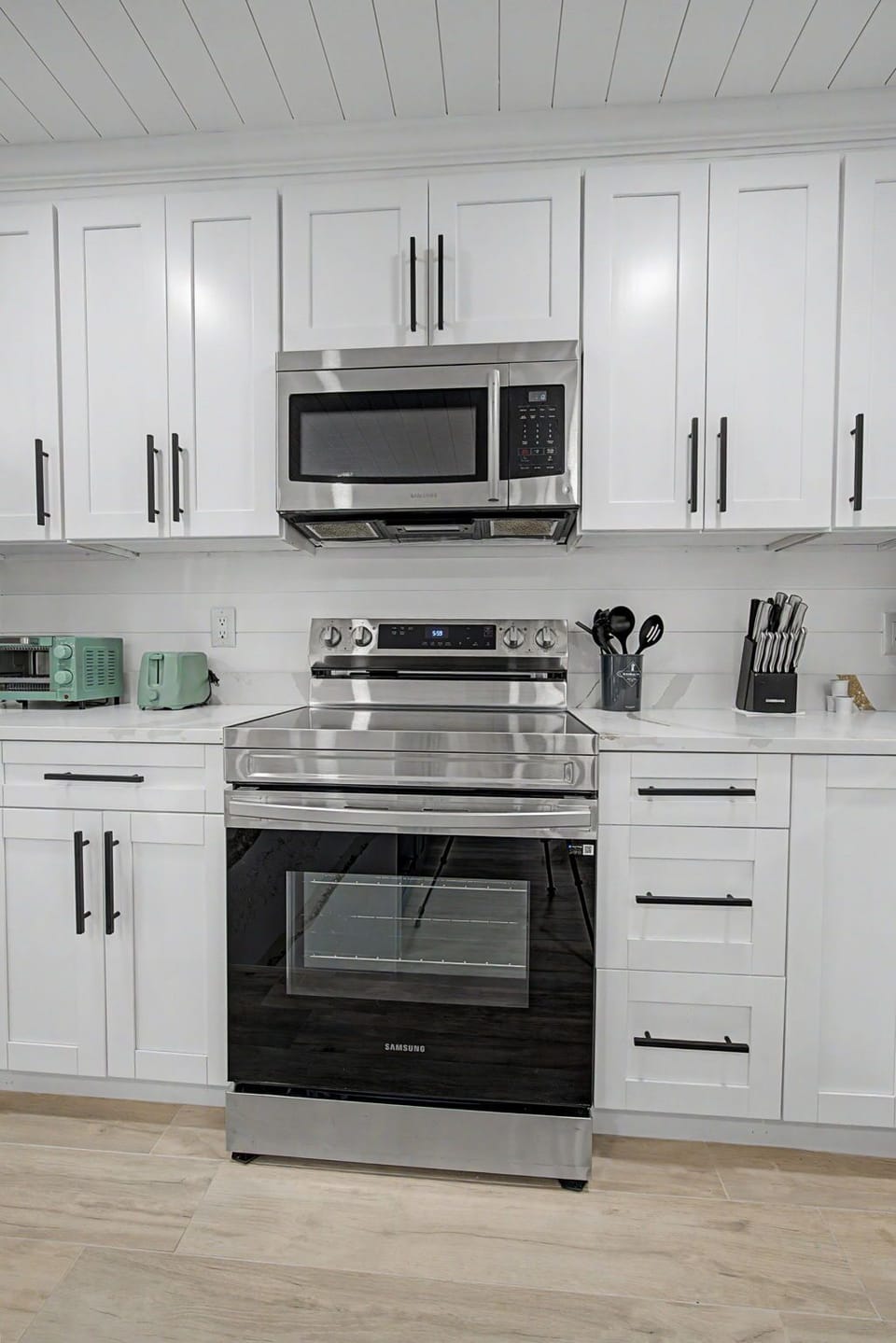 Your fully equipped kitchen awaits with stainless steel appliances and crisp white cabinetry, perfect for preparing meals during your stay.