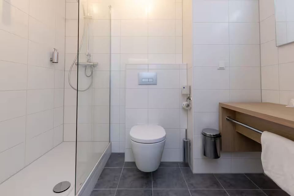 Refresh under a sleek glass shower with bright, clean finishes.