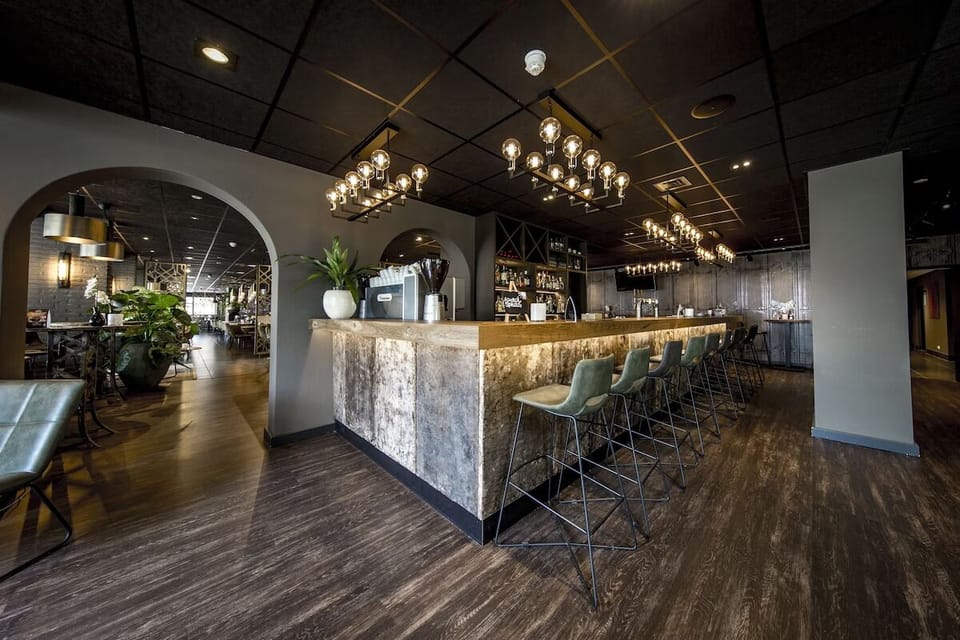 Sip cocktails at the sleek bar with ambient golden lighting.