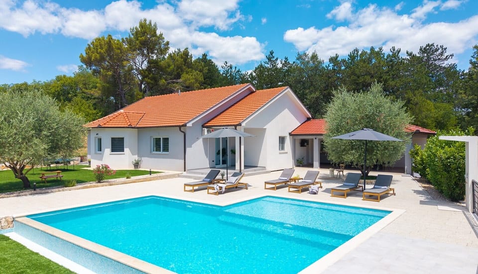 This villa features a stunning 58 sqm infinity pool nestled on a generous 3000 sqm private plot in Grubine.