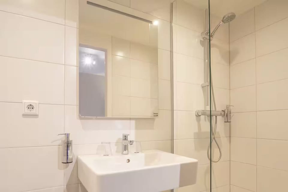 Refresh in a sleek bathroom with glass shower.