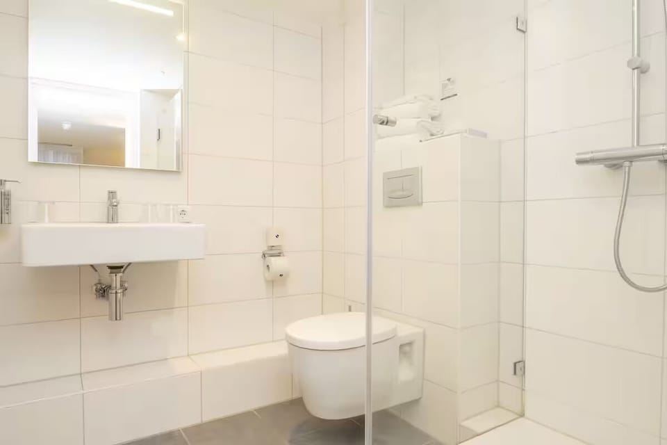 Refresh in a spotless, modern shower with plush towels.