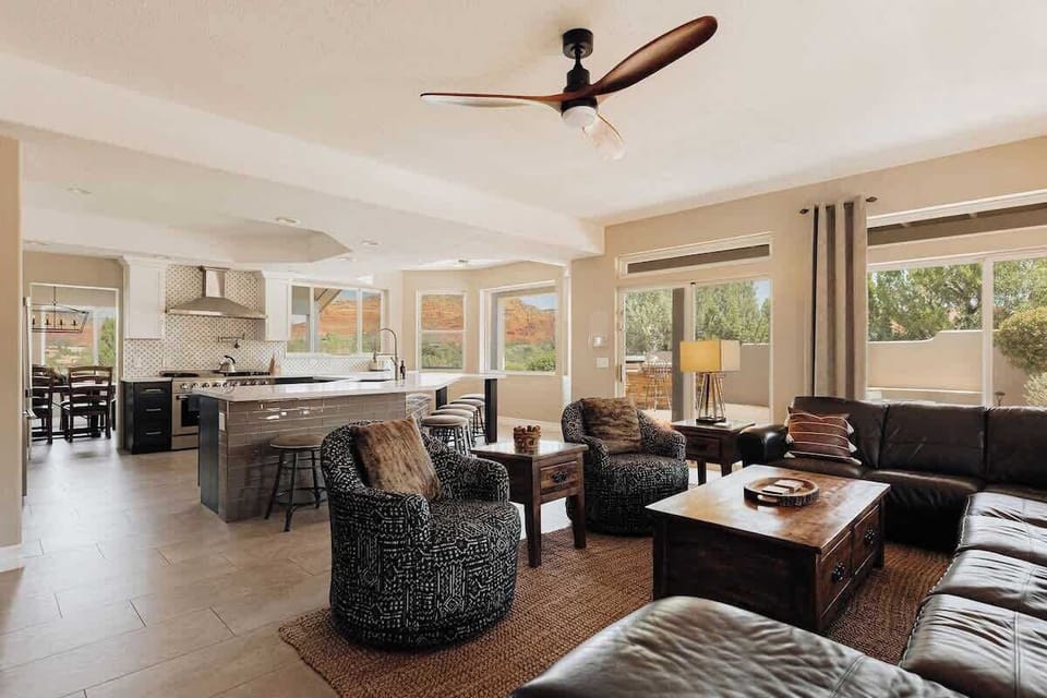 Relax in your spacious open-plan living area with leather seating, modern kitchen, and stunning mountain views through floor-to-ceiling windows.