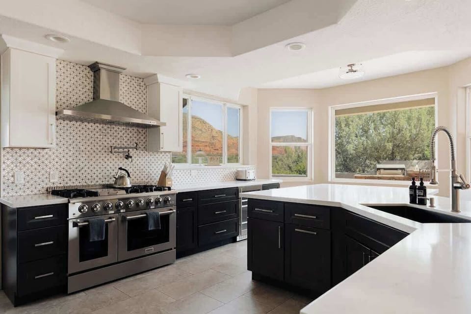 Cook with inspiring mountain views through expansive windows in this stunning modern kitchen, featuring premium appliances and elegant countertops.