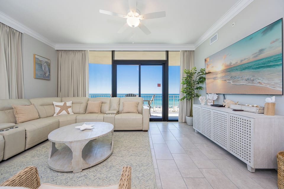 Unwind on your sleek couch while enjoying captivating coastal views through the expansive glass doors