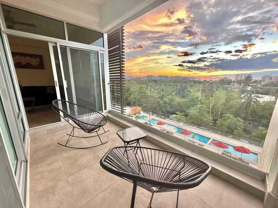 Private balcony w/ lounge chairs overlooking treetops & glowing sunset views