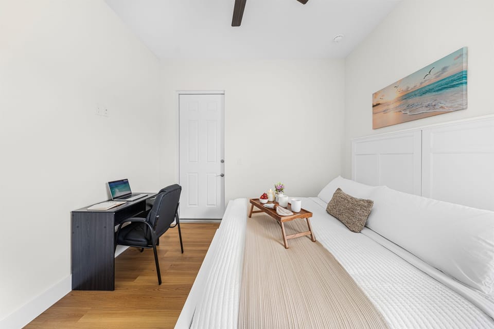 Wake up refreshed in a bright, comfortable bedroom with quality bedding and a handy workspace nearby.