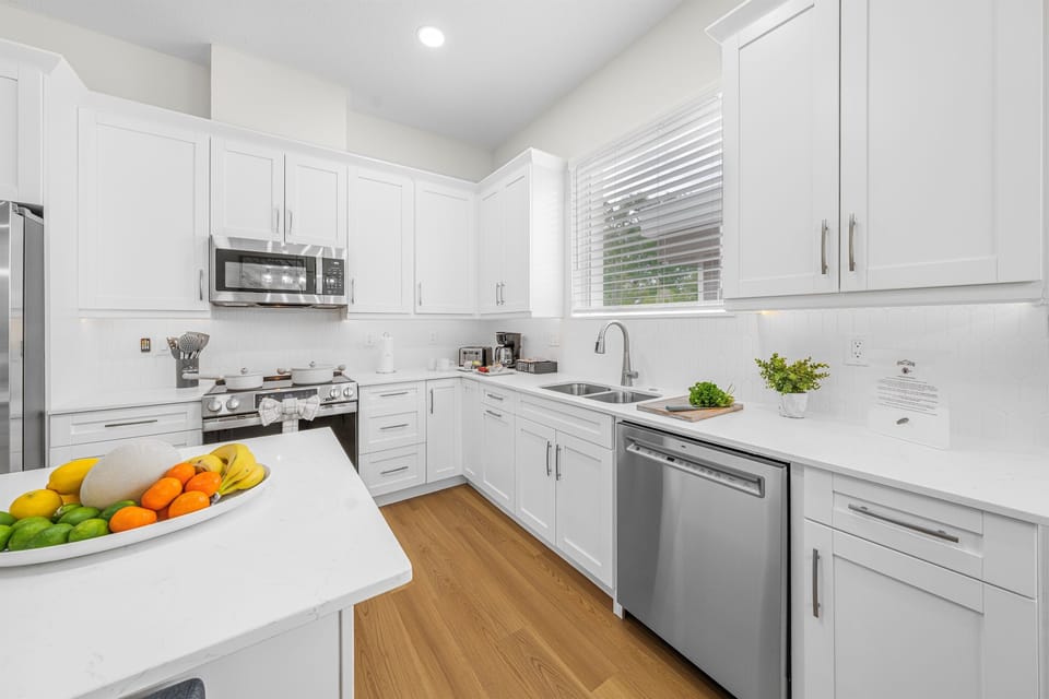 Bright and modern kitchen with sleek white cabinetry, stainless steel appliances, and plenty of counter space for cooking and entertaining.