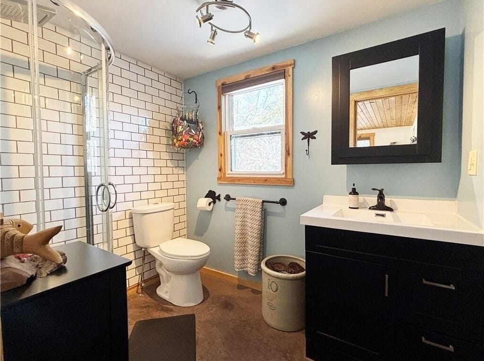 Bright modern bathroom with subway-tile shower and stylish black accents