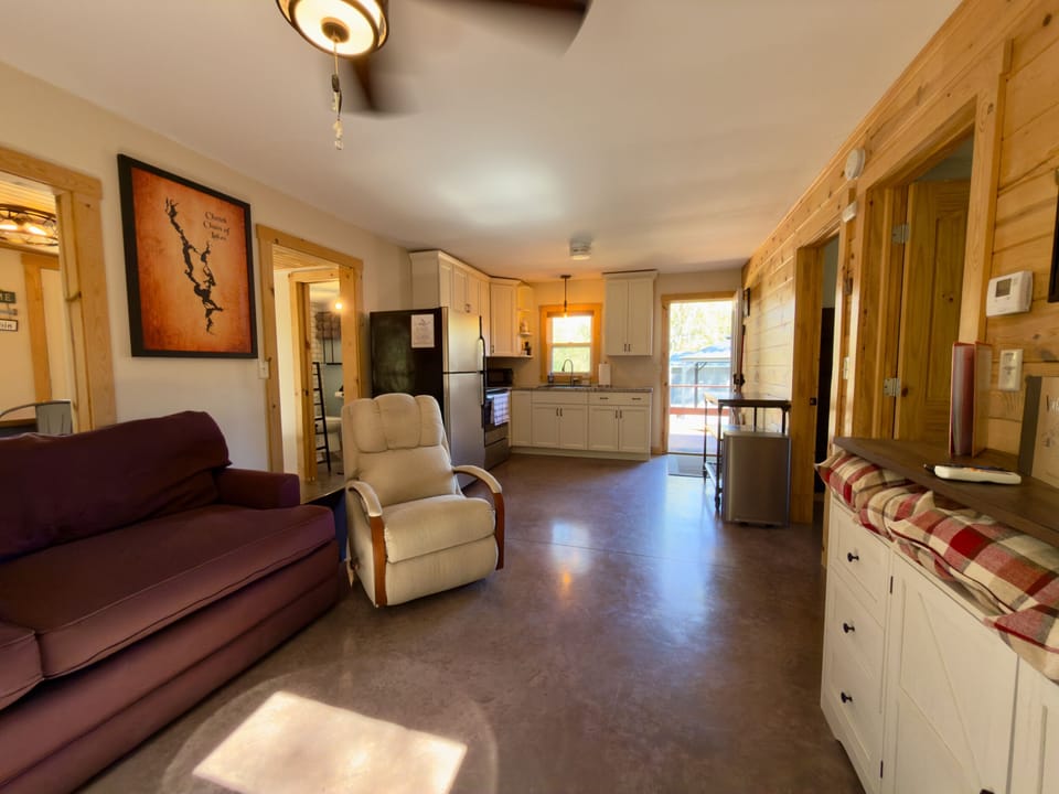 Cozy cabin-style living space with full kitchen and bright deck access