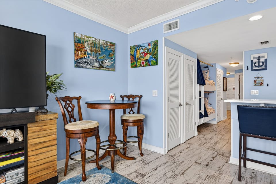 There is a small dining table, perfect for enjoying a meal or playing a game, as well as additional breakfast bar seating.