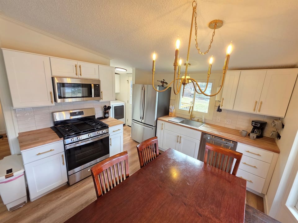 Kitchen  with stainless steel appliances 
and dining area.