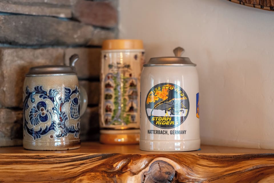 Your cozy retreat features authentic German beer steins displayed on rustic wooden shelves, adding cultural charm to your mountain getaway.