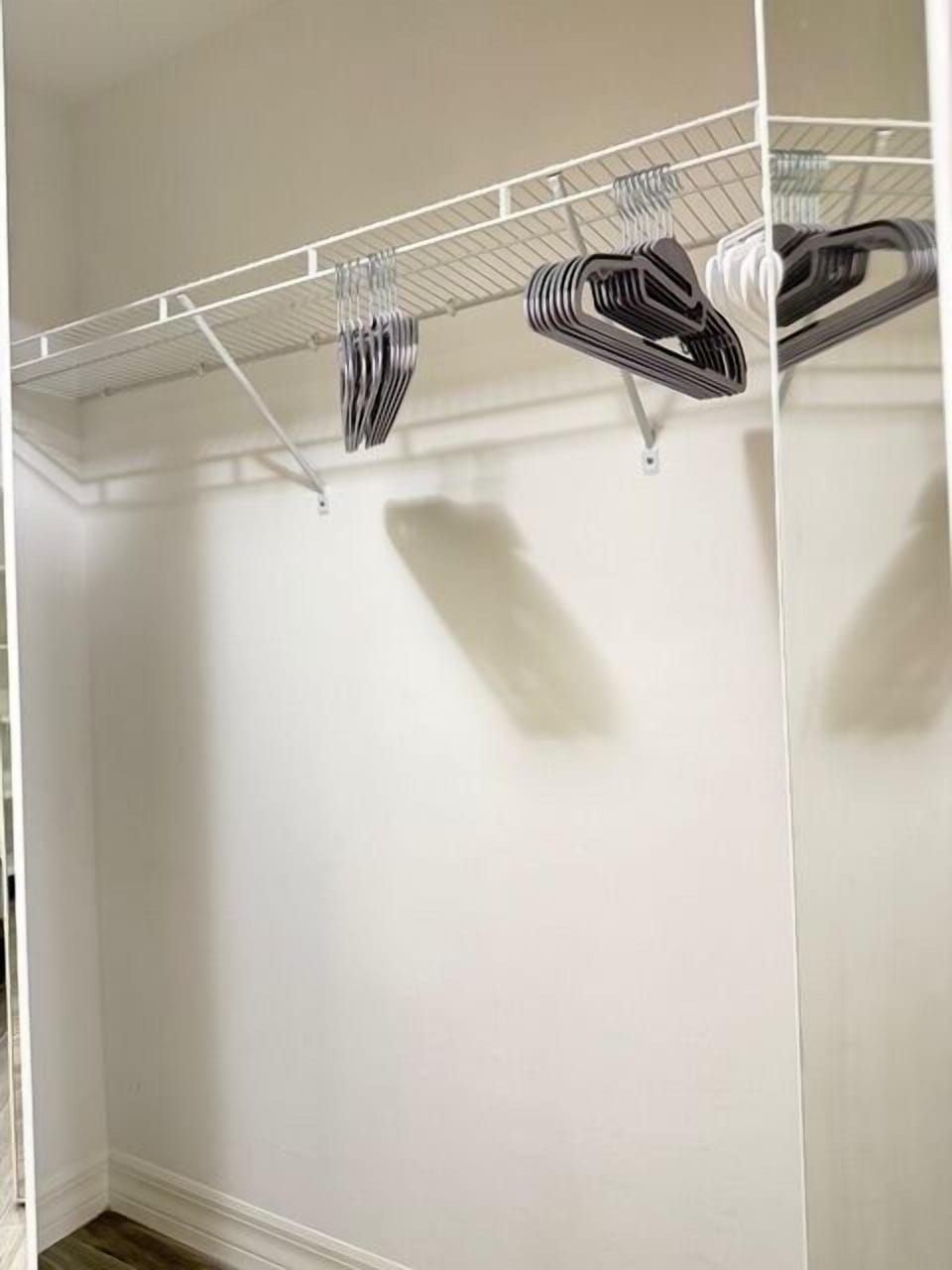 Main bedroom closet 1 Your spacious walk-in closet features wire shelving and hangers, providing ample storage space for all your belongings during your stay.