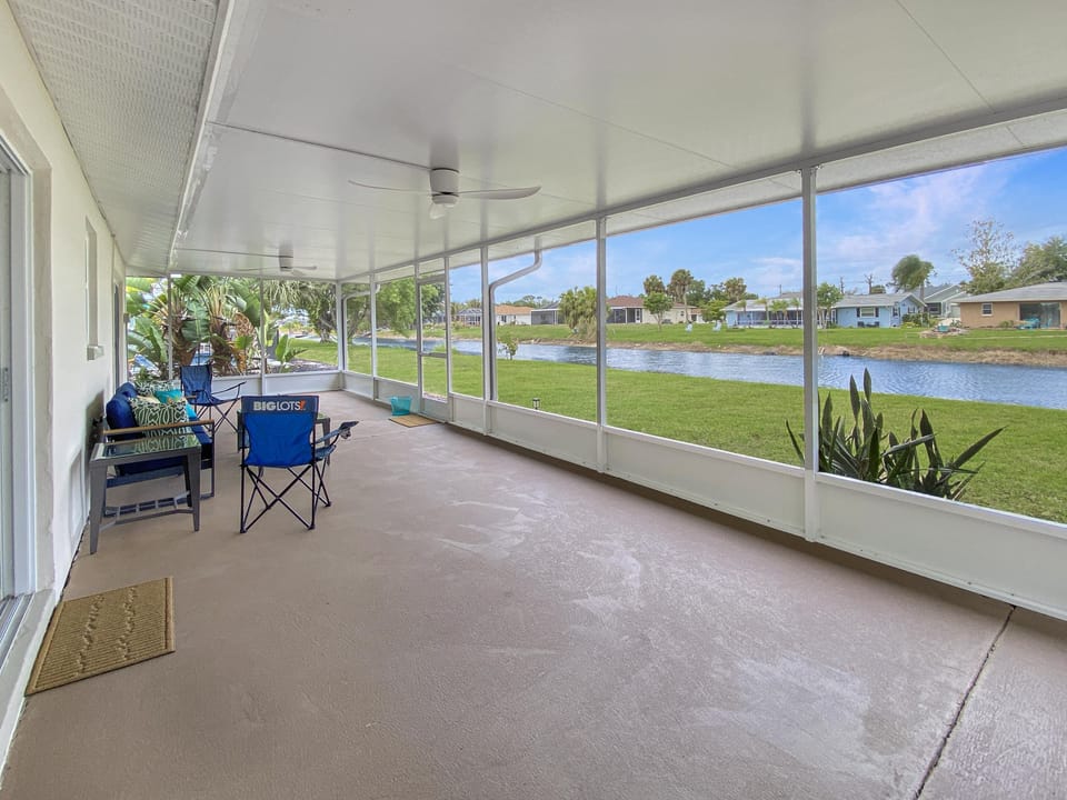 Spacious screened porch with serene canal views, perfect for relaxation.