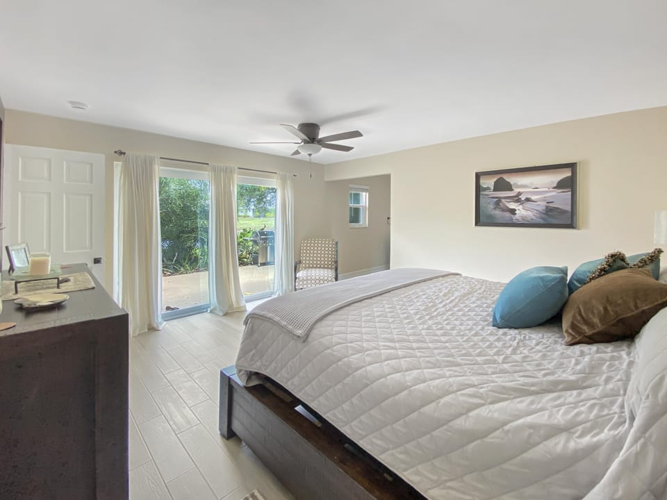 Bright bedroom with patio access and serene garden views.