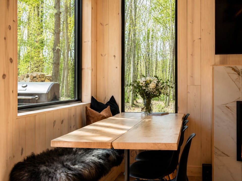 Corner dining nook with live-edge table, grill just outside.