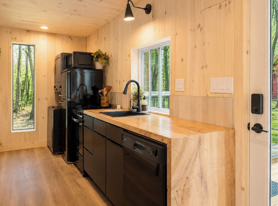 Full kitchen with butcher block counters and forest views.