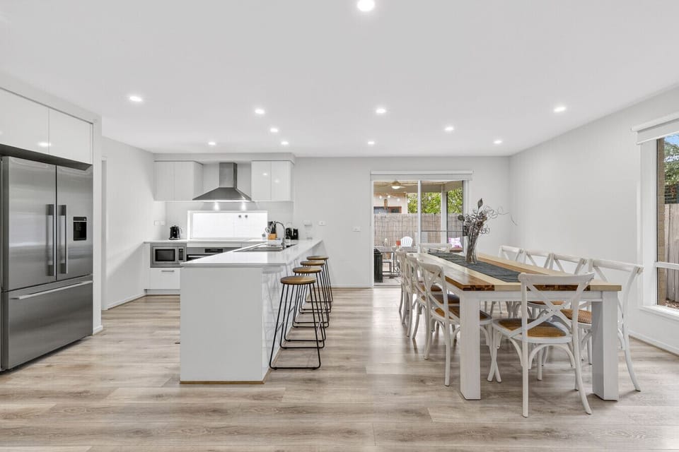 Spacious open-plan kitchen and dining area with large table and modern appliances