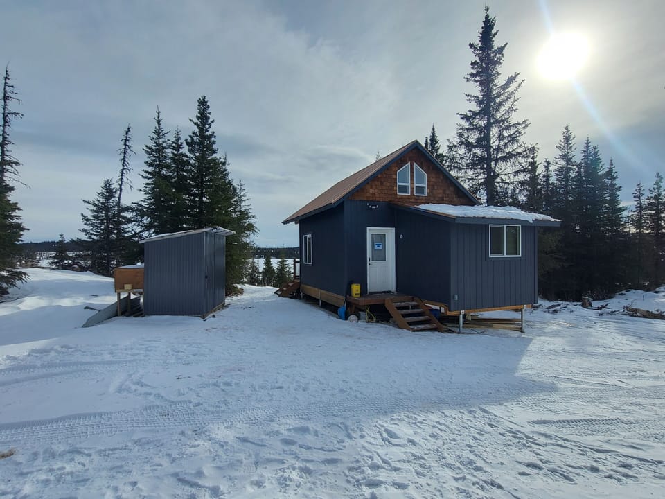Back of Cabin and Outhouse to the left side, Caribou Lake in the background