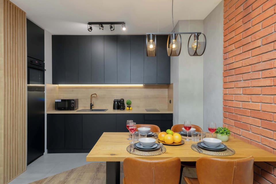 A sleek kitchen corner with matte dark cabinetry and a light backsplash, creating a modern contrast. 