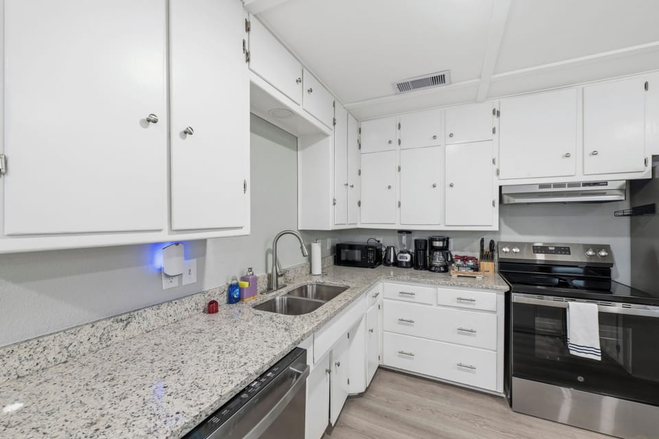 Every detail considered—the kitchen is fully equipped with stainless appliances and a convenient coffee station.