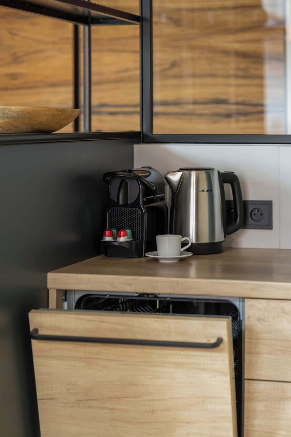 A kitchen detail showcasing a modern coffee maker and minimalist shelves for kitchen accessories.