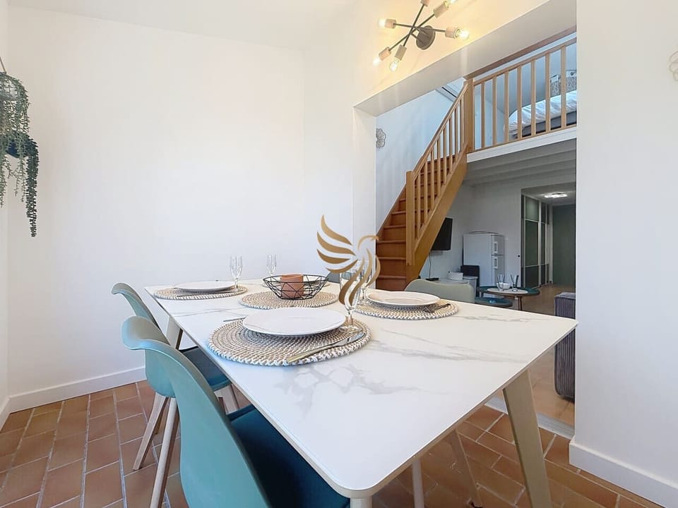 Espace de vie fonctionnel avec accès au duplex et coin repas moderne
