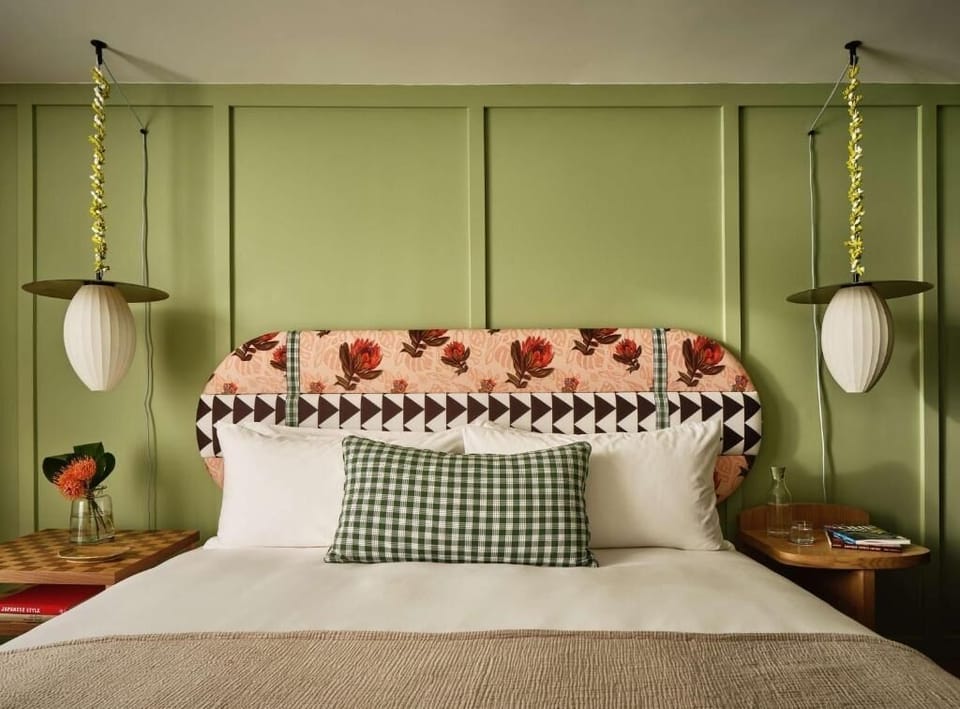 Unwind in crisp linens beneath bold, design-forward headboard.