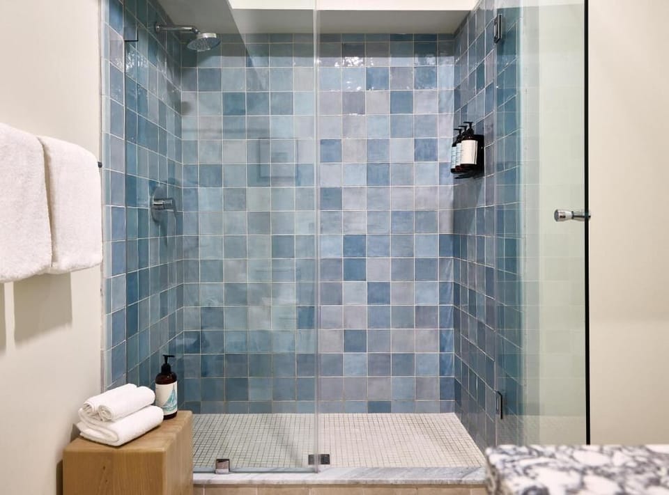 Refresh under a spacious glass shower with spa-like tiles.